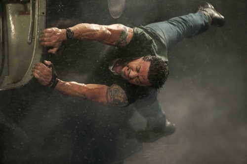 Sylvester Stallone, fights wind and rain as he boards a seaplane on "The Expendables."  Photo by Karen Ballard